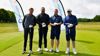 Four men standing with golf clubs in front of Demelza banners at the London Golf Club for the Demelza Golf Day