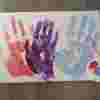 A page of hand prints in red, purple and blue colour paints