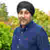 Trustee Ziggie Singh standing in a garden, wearing a black turban and a smart navy blue shirt.