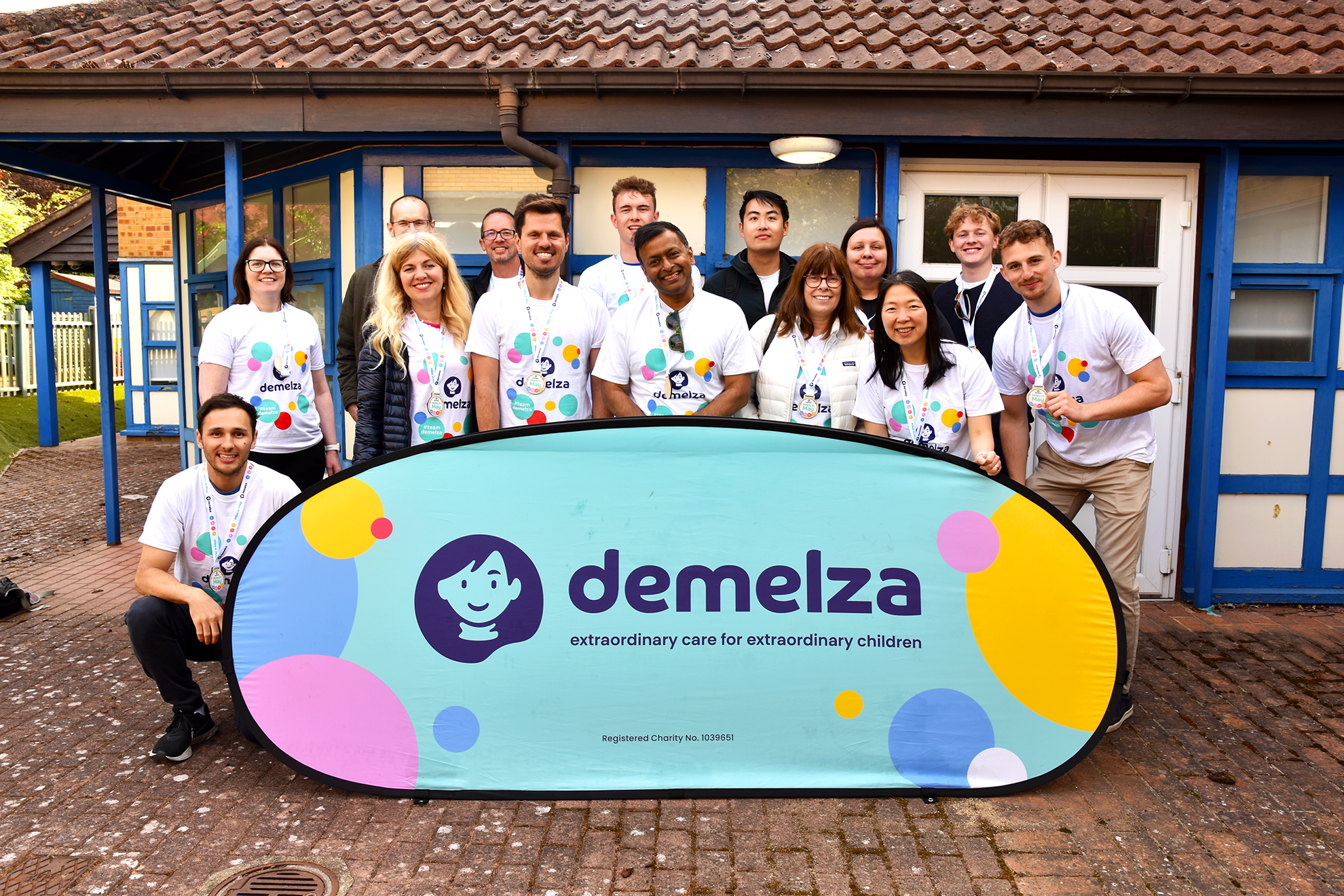 Corporate team with Demelza branded sign