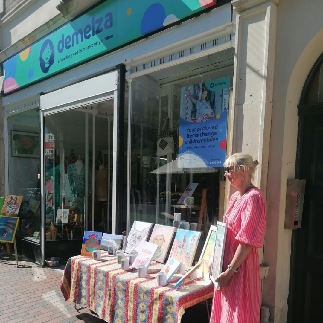 Artist with works of art outside Demelza shop