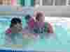 Young person in pool with family
