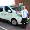 Practical support driver standing next to transport vehicle