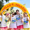A group of four girls covered in bubbles standing in front of a yellow inflatable that says "Hello Yellow" at Bubble Rush in Eltham
