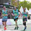 Three men running in Demelza shirts at the Paris Marathon 2026