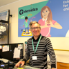 Retail volunteer Nathan at the Maidstone Earl Street shop till, wearing a striped top and smiling warmly.